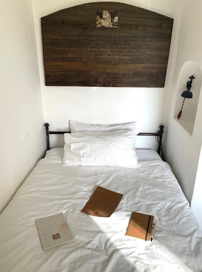 a bed with white sheets and books on it