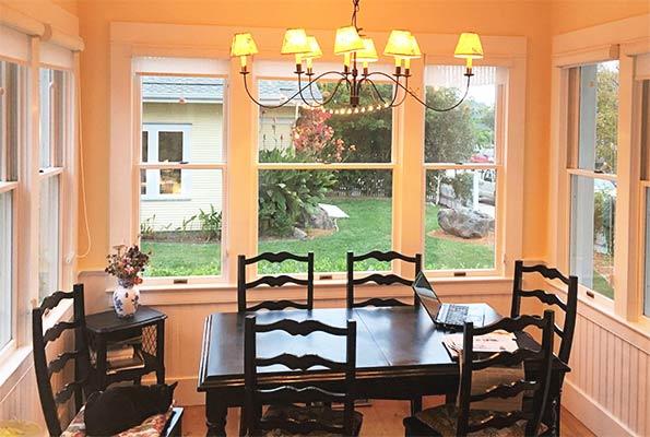 a dining room with a laptop and chairs