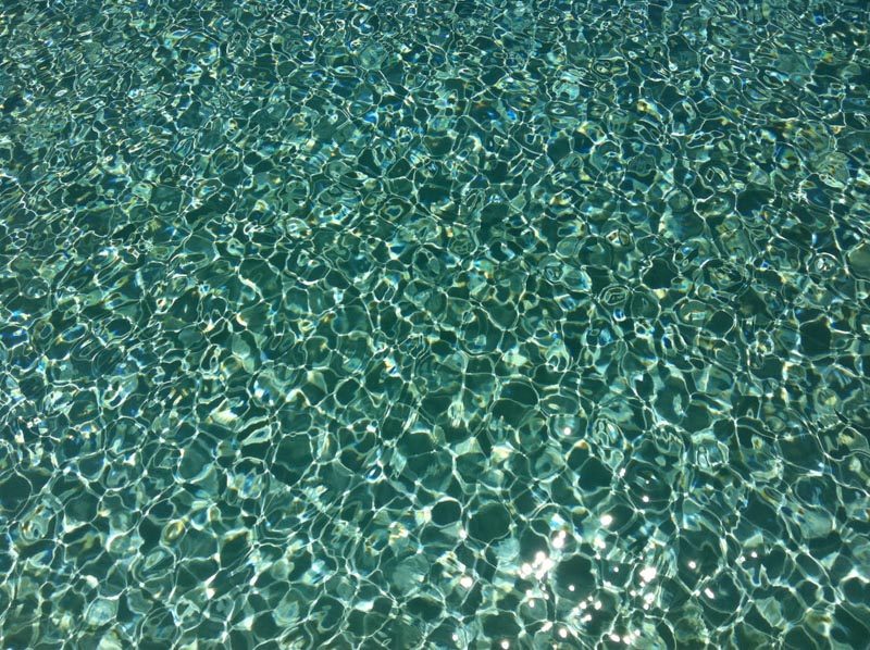 a clear blue water with ripples